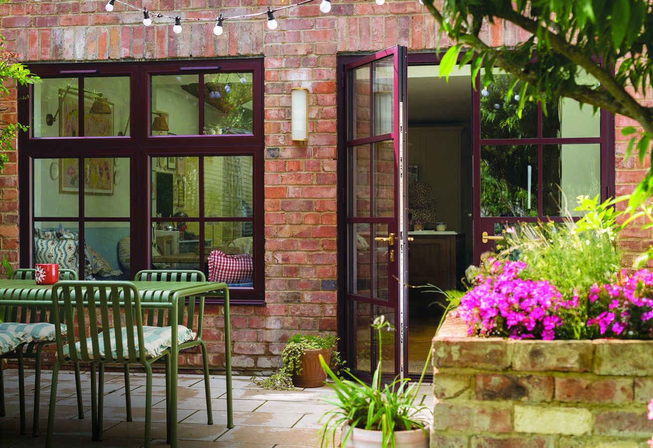 Georgian style: deep red glazing-bar french doors in a brick courtyard