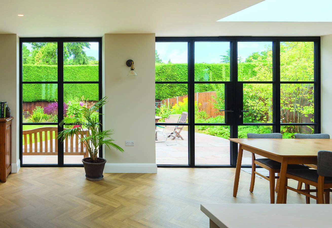 Soho style: jet black glazed doors with fine grids, seen from a bright kitchen